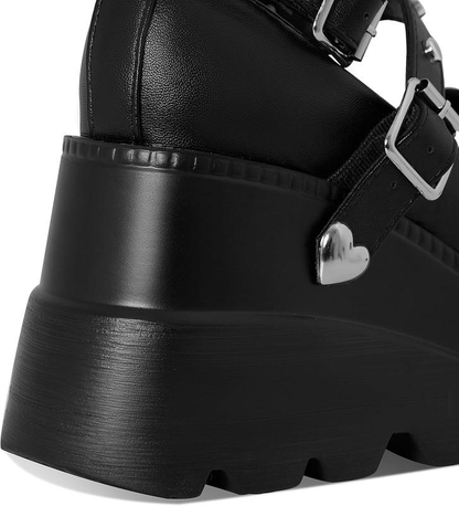 Close-up of black platform heel and heart detail
